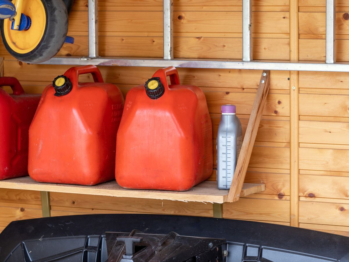 Cans of gasoline in a garage that are expired and need to be disposed of properly