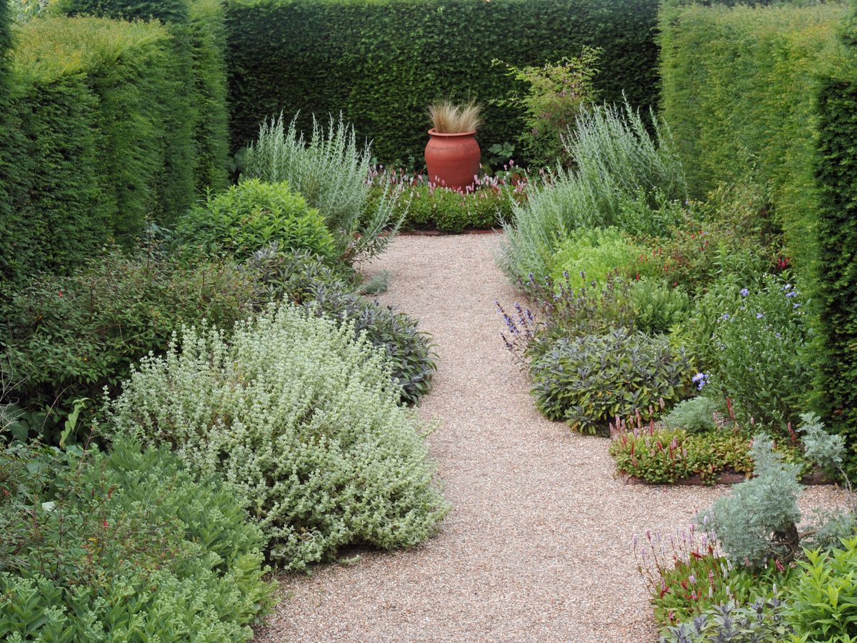a gravel walkway and surrounding bushes