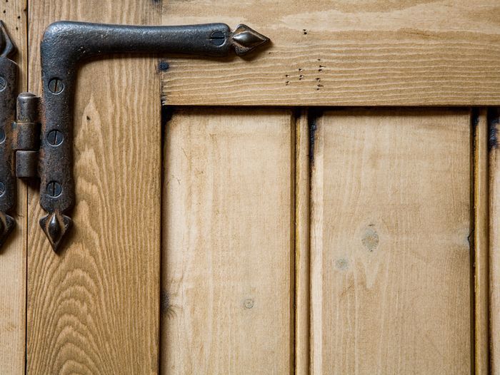 A hinge on the corner of a cabinet door.