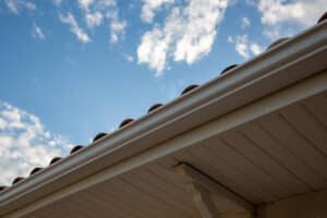 new modern house with gutter roof wall under blue cloud sky
